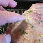 Inserting garlic cloves into slits cut in the lamb