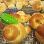 Brushing baked bunnies with honey/butter glaze